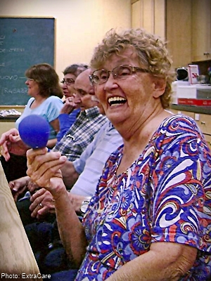seniors at a table engaged in a game with balloons