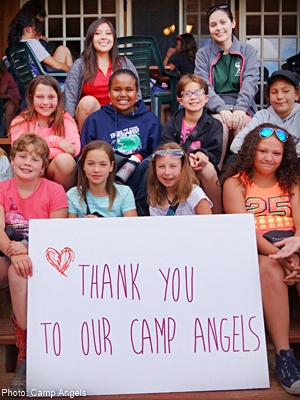 a bunch of kids at camp on a porch with a sweet handmande thank you sign